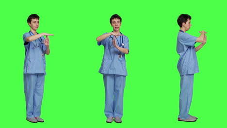 Medical-assistant-giving-timeout-symbol-against-greenscreen-backdrop